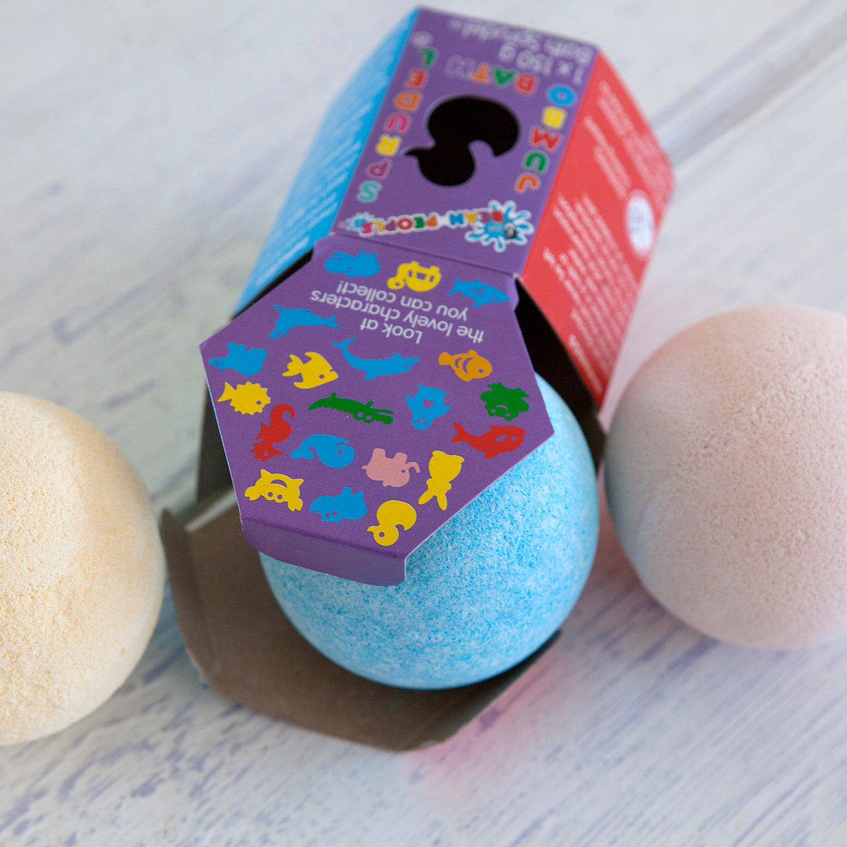 Jumbo Bath Bomb Sprudel in its purple box with bath bombs beside it