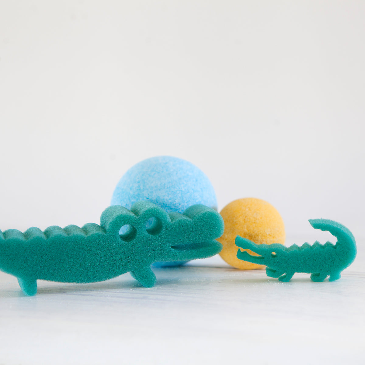 Jumbo and single bath bombs with green crocodile sponge toys
